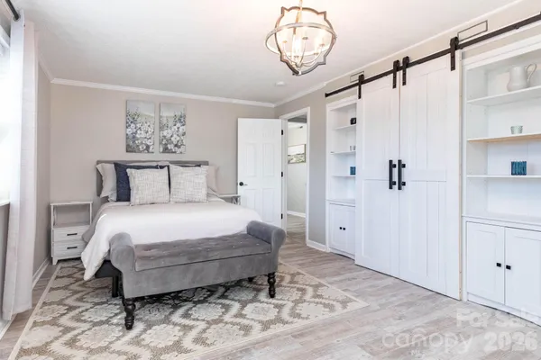 a bedroom with a bed and a chandelier