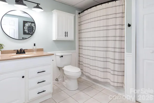a bathroom with a toilet sink vanity and mirror