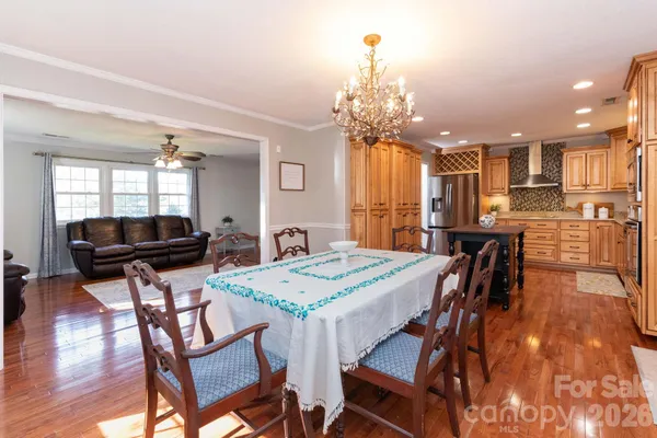 a kitchen with a dining table chairs and refrigerator