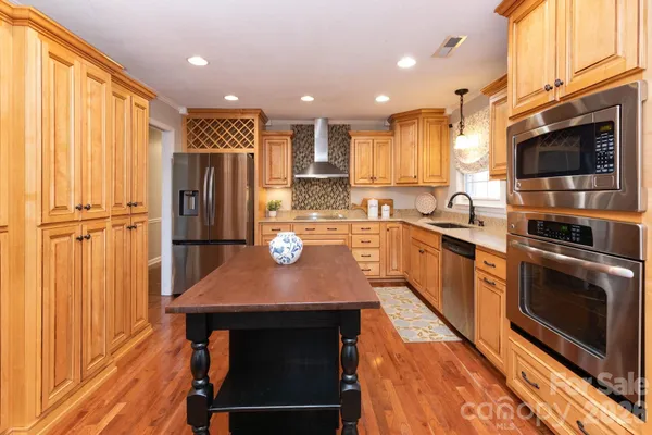 a kitchen with stainless steel appliances granite countertop a sink a stove and a refrigerator