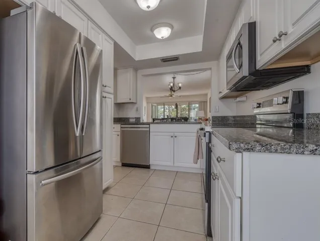 a kitchen with stainless steel appliances granite countertop a refrigerator sink and cabinets