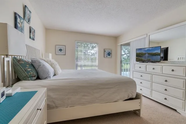 a bedroom with a large bed and a flat screen tv