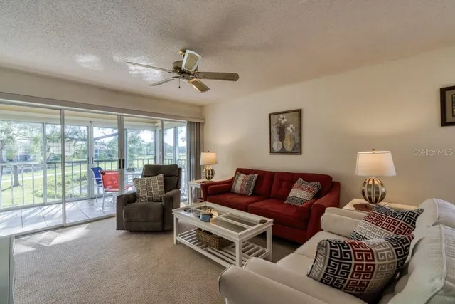 a living room with furniture and a large window with balcony view