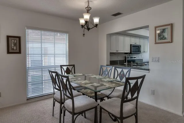 a view of a dining room with furniture and a chandelier