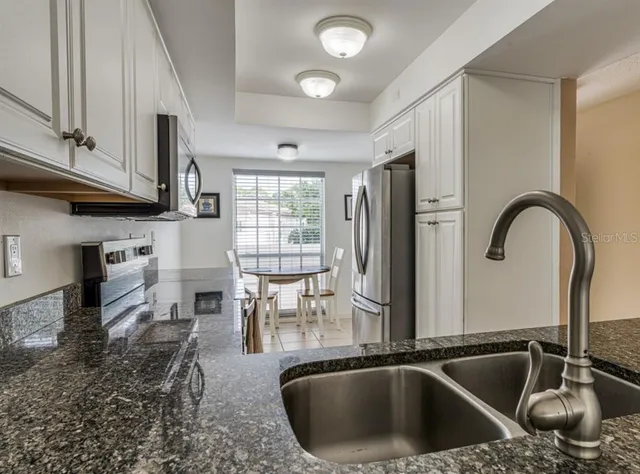 a kitchen with kitchen island a sink appliances and cabinets