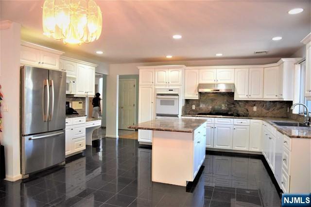 39 Irving Avenue Englewood Cliffs, NJ 07632 - Photo 6 of 31 a kitchen with stainless steel appliances granite countertop a refrigerator and a stove top oven