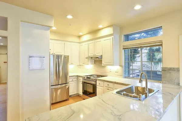 a kitchen with stainless steel appliances granite countertop a stove and a sink