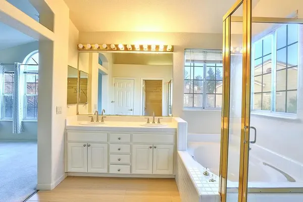 a bathroom with a tub sink and mirror