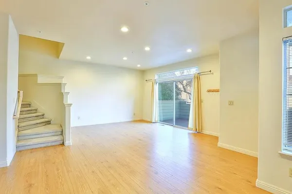 a view of a hallway with wooden floor and a bathroom
