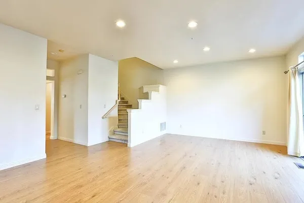 a view of empty room with wooden floor