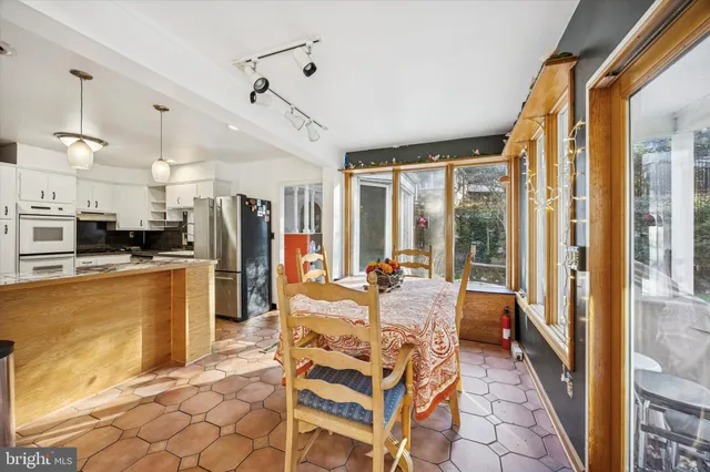 a view of a dining room with furniture a chandelier and kitchen view
