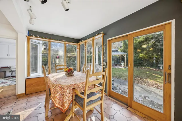 a dining room with furniture and large windows