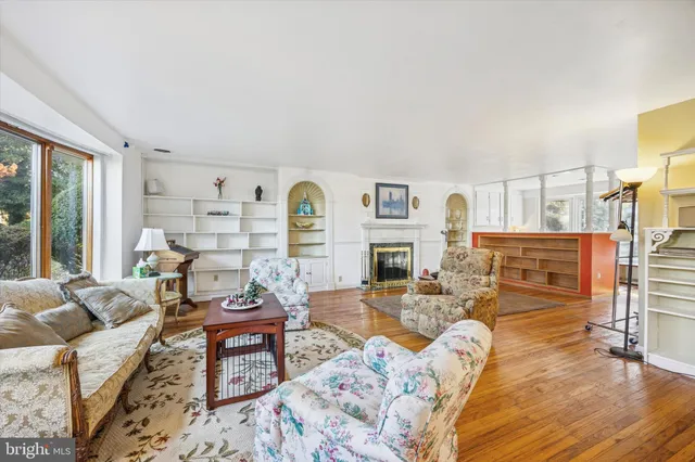 a living room with fireplace furniture and a wooden floor