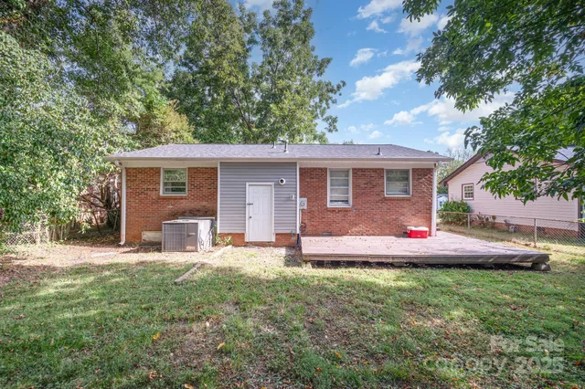 a front view of house with yard and trees in the background
