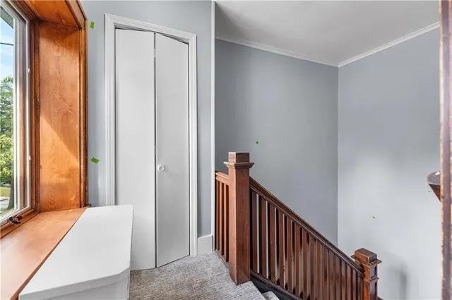 a view of a hallway with a large window and stairs