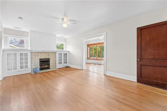 a view of an empty room with a window and fireplace