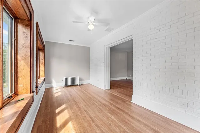 a view of a livingroom with wooden floor and an entryway