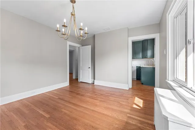 a view of a big room with wooden floor and chandelier