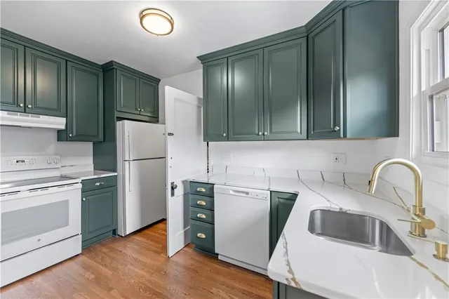 a kitchen with a refrigerator sink and cabinets