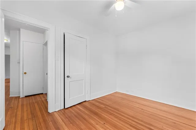 a view of a room with wooden floor and a ceiling fan
