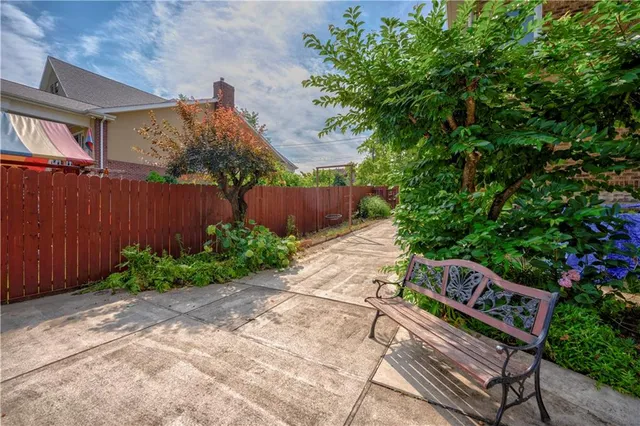 a view of a yard with plants and wooden fence