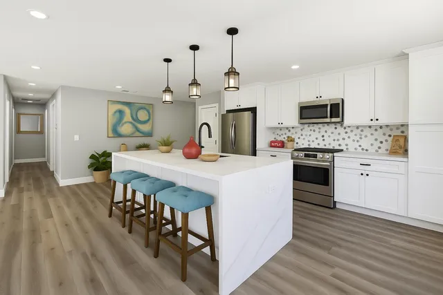 a kitchen with stainless steel appliances granite countertop a sink stove and microwave