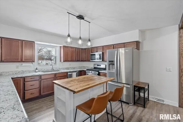 a kitchen with stainless steel appliances granite countertop a sink a stove and a refrigerator