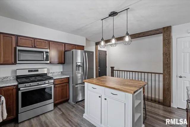 a kitchen with granite countertop a stove and a microwave