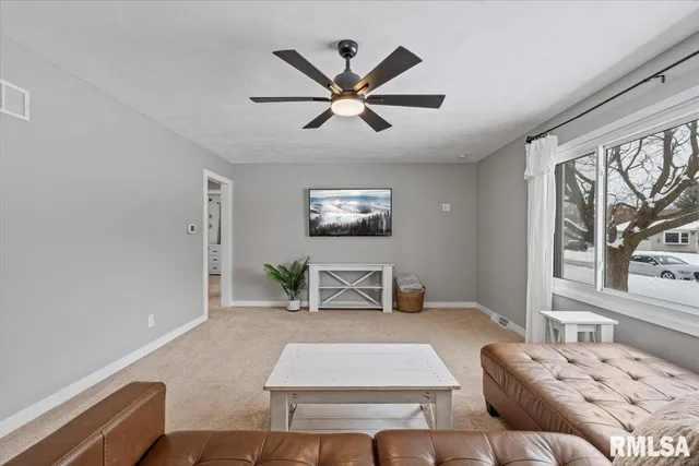 a living room with furniture and a ceiling fan