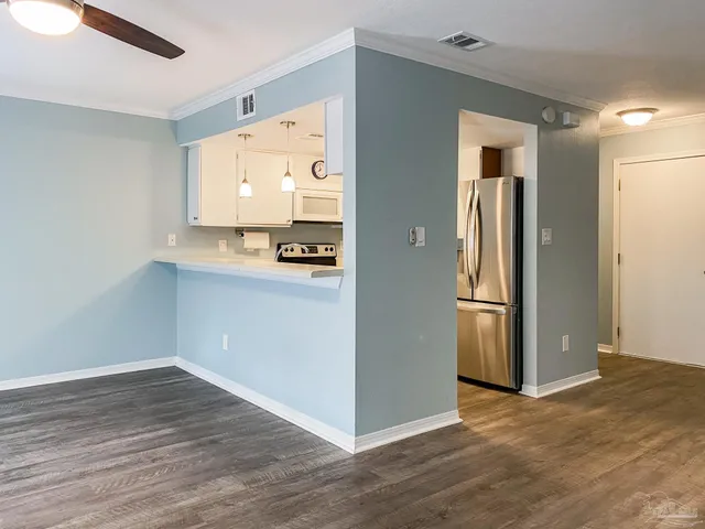 a view of a kitchen with wooden floor and a refrigerator