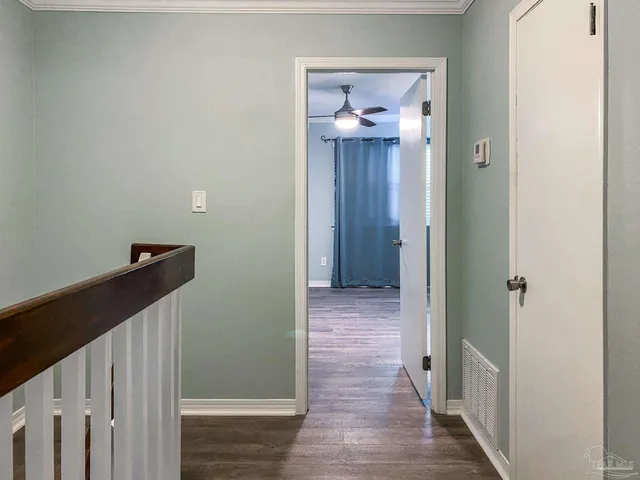 a view of a hallway with wooden floor and staircase