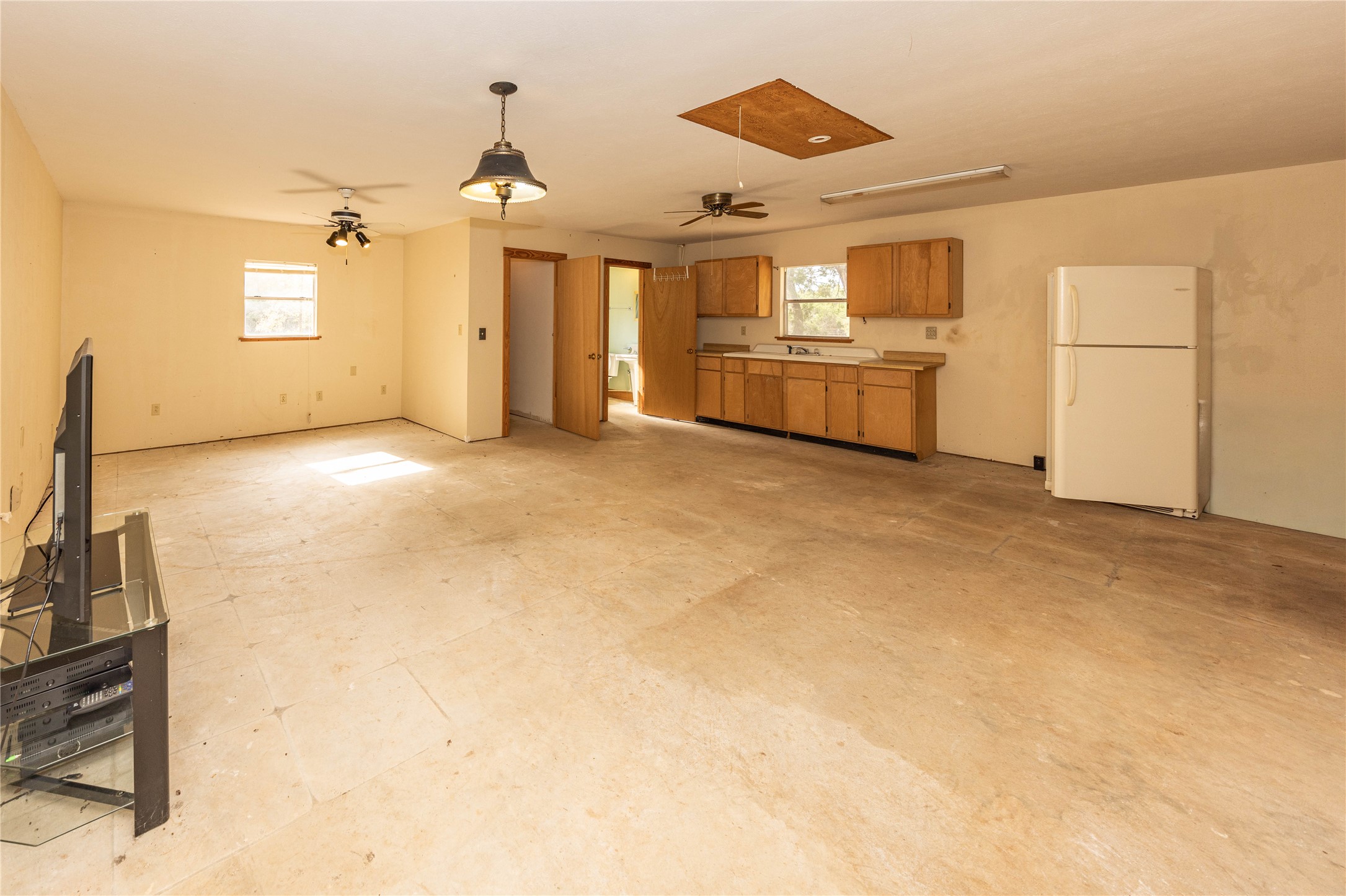2501 Fischer Store Road Wimberley, TX 78676 - Photo 14 of 23 Open concept space featuring a partial kitchen with wood cabinetry, a built-in sink, and countertop space