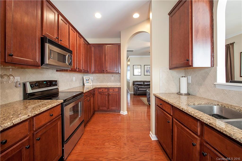 1903 Travertine Lane, Unit 1903 Fort Mill, SC 29708 - Photo 5 of 16 a kitchen with stainless steel appliances granite countertop a sink stove and cabinets