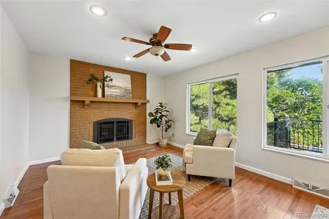a living room with furniture fireplace and a large window
