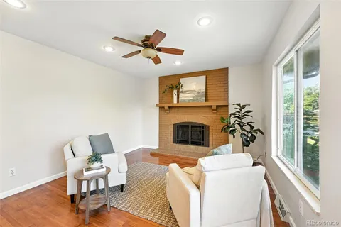 a living room with furniture a fireplace and a large window