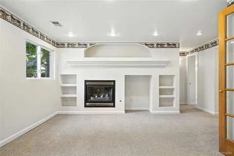 a view of an empty room with a fireplace and a window