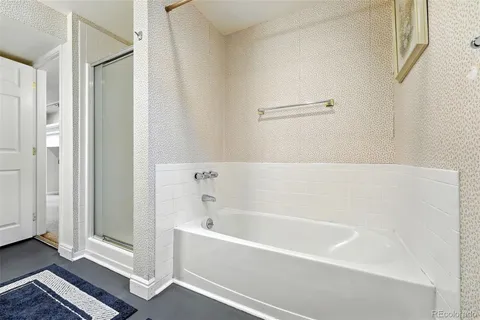 a white bath tub sitting next to a shower