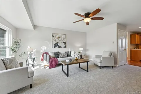 a living room with furniture and a ceiling fan
