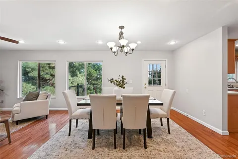 a view of a dining room with furniture a rug and wooden floor