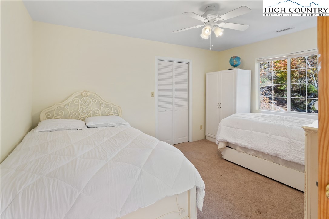 2161 Stone Mountain Road Vilas, NC 28692 - Photo 11 of 50 a bedroom with a bed and a chandelier