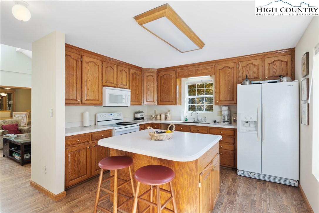 2161 Stone Mountain Road Vilas, NC 28692 - Photo 13 of 50 a kitchen with stainless steel appliances a sink a stove a refrigerator and island with wooden floor