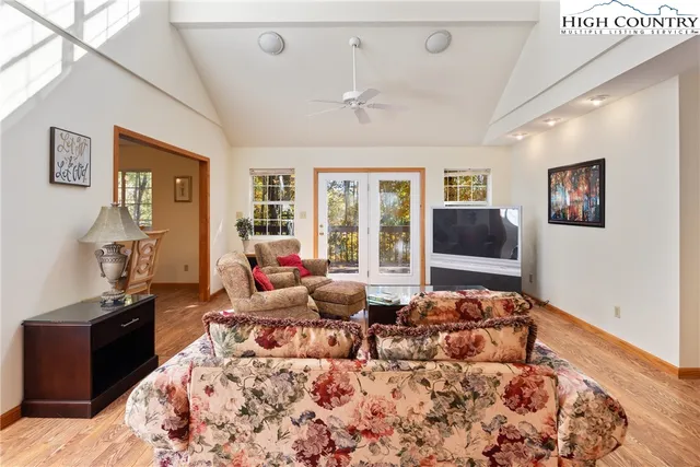 a living room with furniture large window and flat screen tv