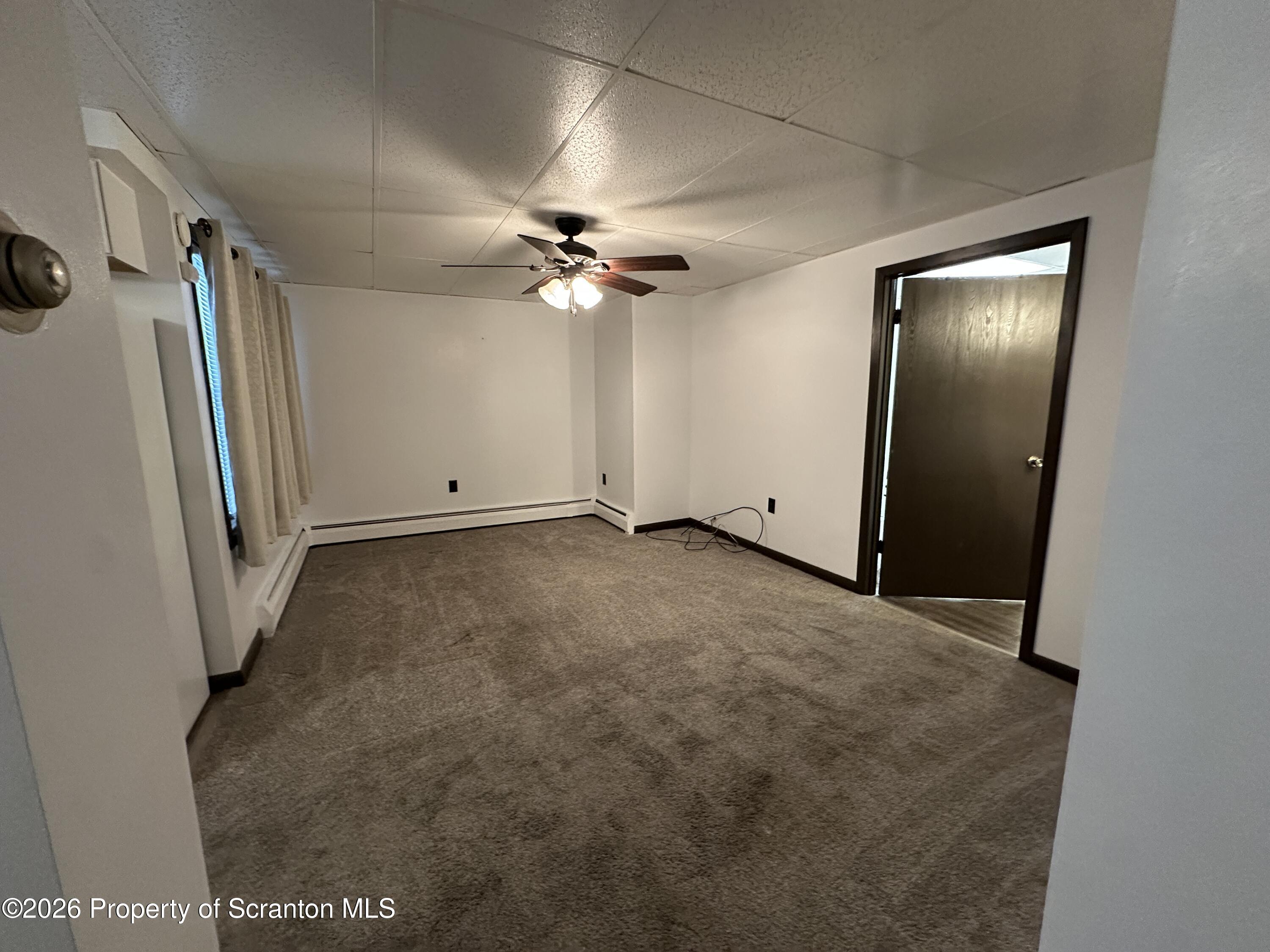 548 Main Street, Unit REAR Dickson City, PA 18519 - Photo 6 of 13 an empty room with windows and fan