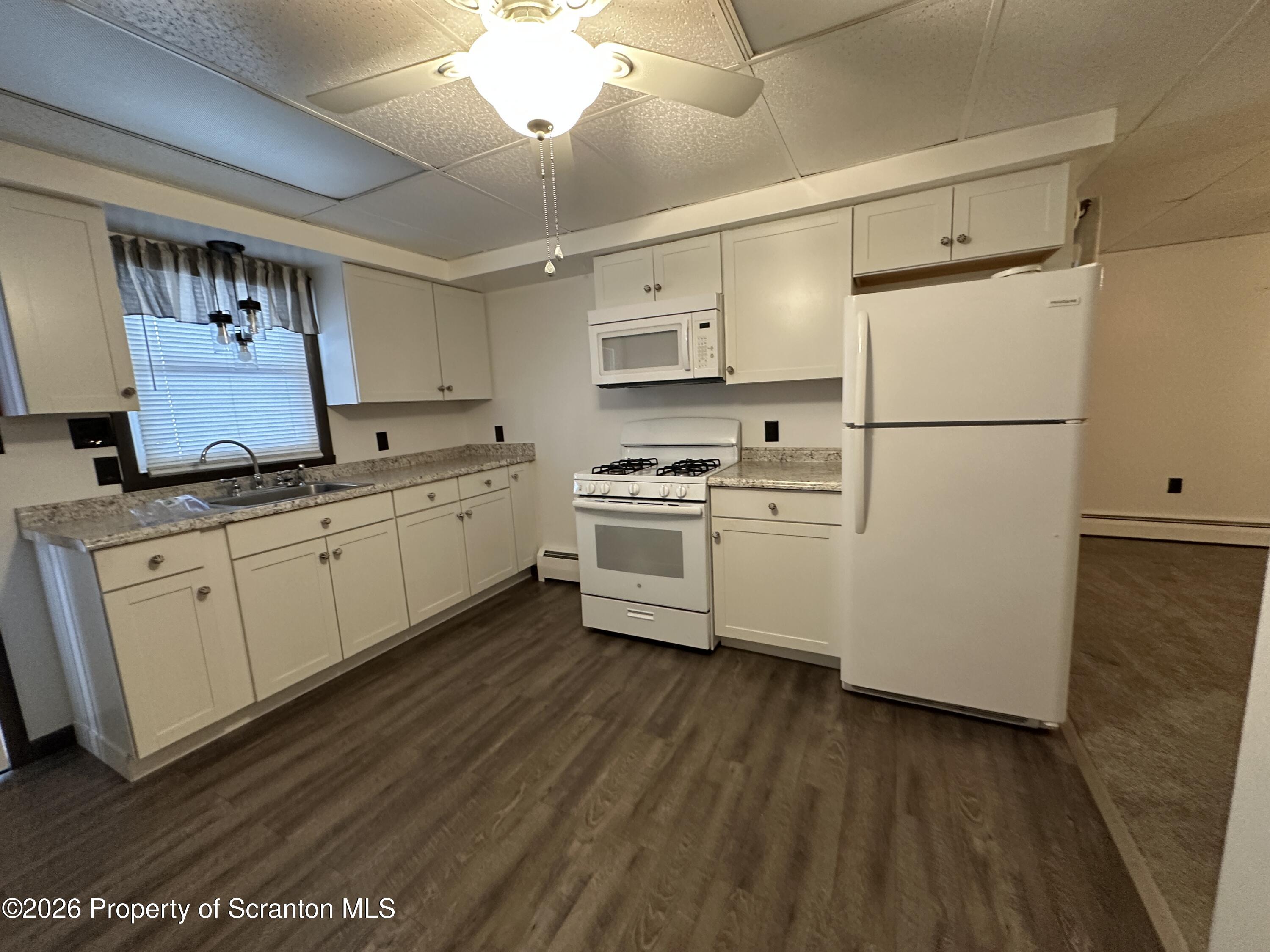 548 Main Street, Unit REAR Dickson City, PA 18519 - Photo 8 of 13 a kitchen with stainless steel appliances a refrigerator sink and cabinets