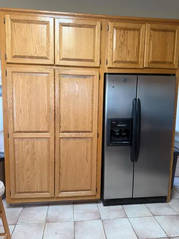 a view of a refrigerator in kitchen and a window