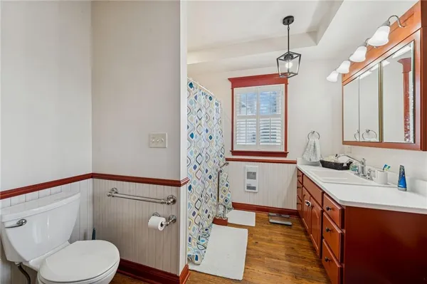 a bathroom with a sink a toilet a mirror a vanity and window