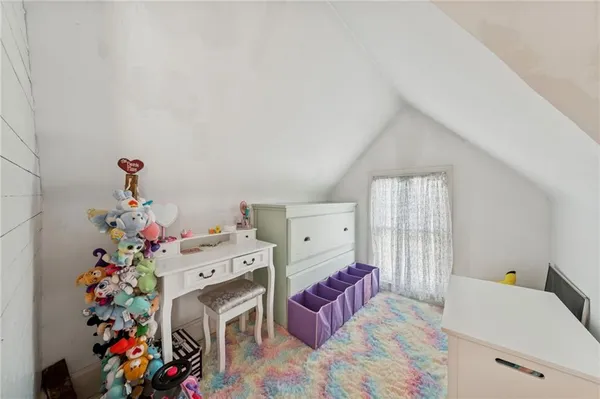 a living room with furniture and a baby crib