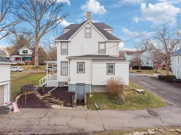 a view of a white house with a yard