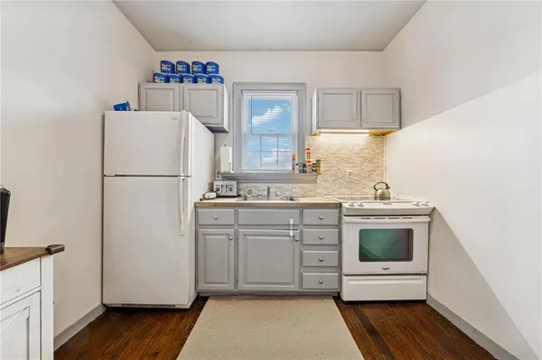 a kitchen with a refrigerator sink and cabinets