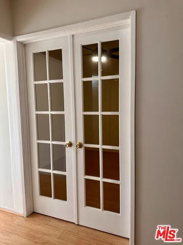 a view of an empty room with wooden floor and closet